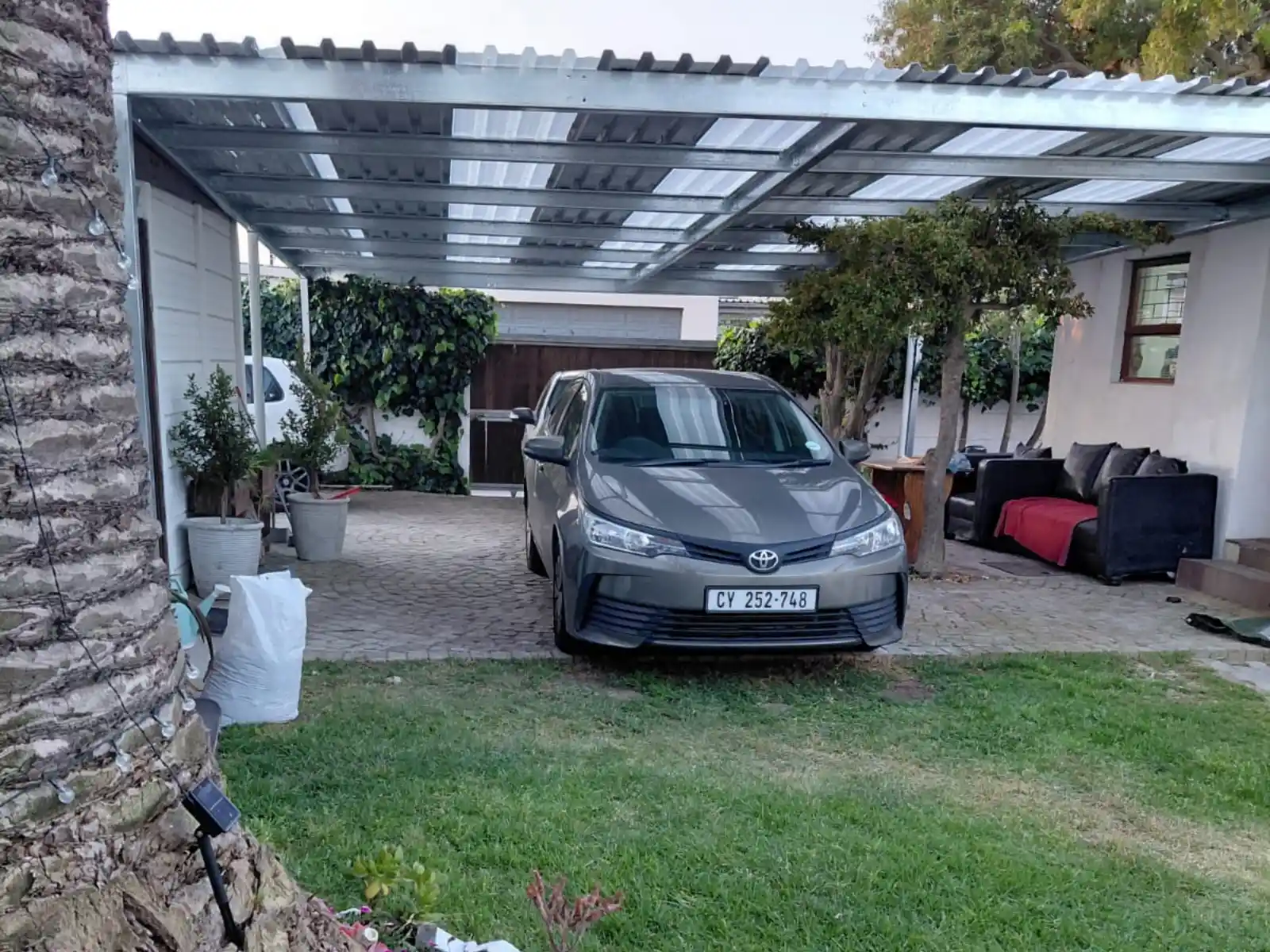 Completed galvanised steel carport with car parked, Plumstead